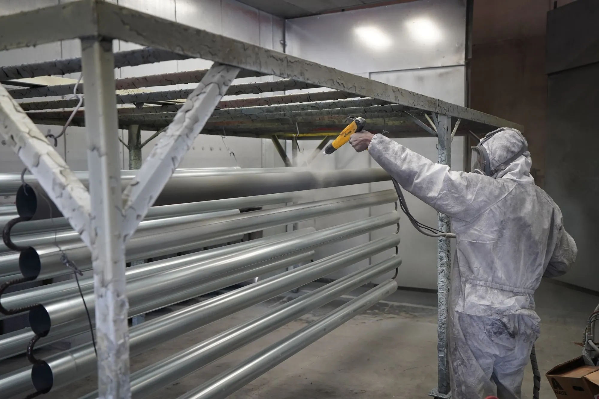 Laquage de profilés en aluminium dans une cabine.