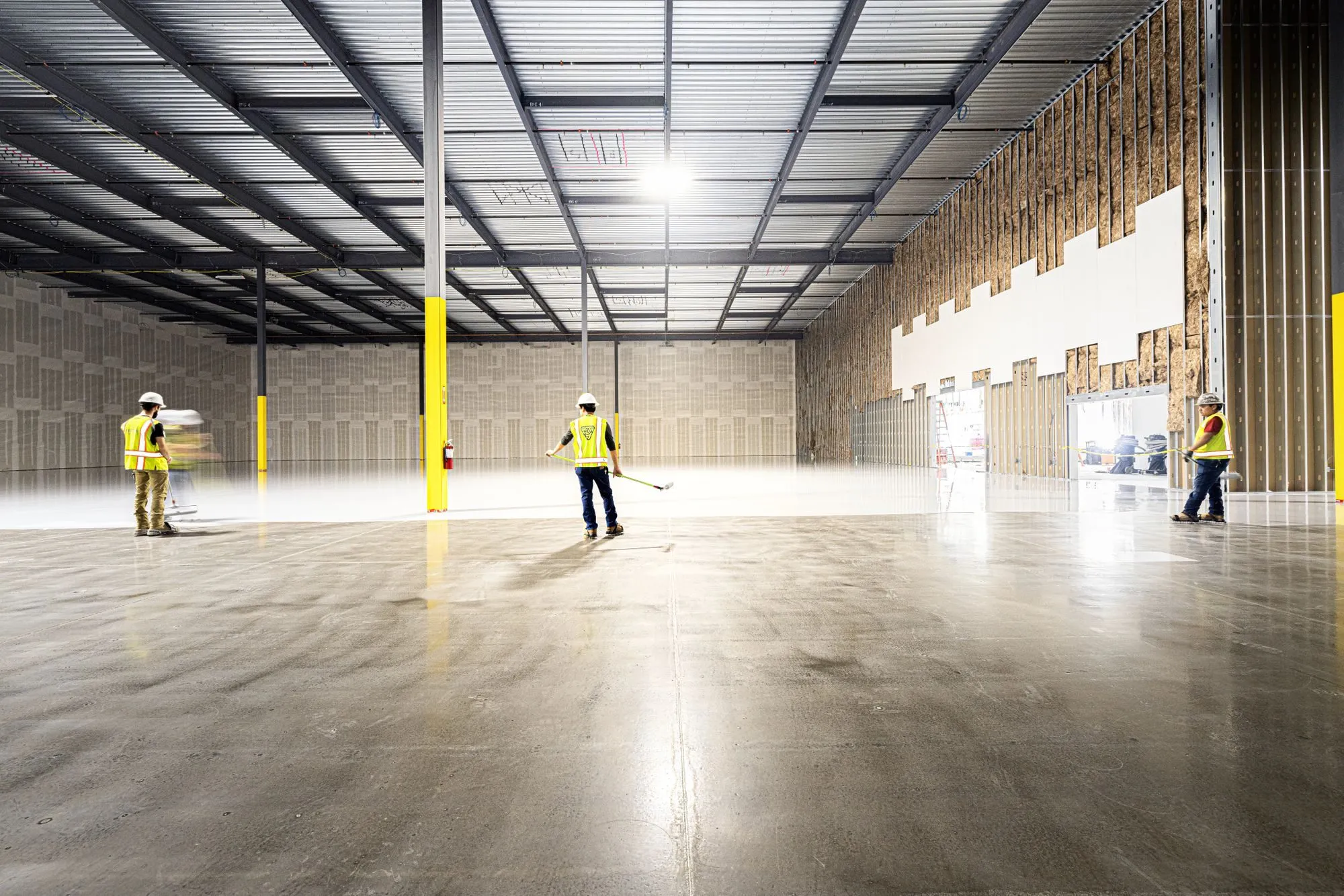 Hall d'entrepôt au béton nu, préparé avant l'application de la résine.